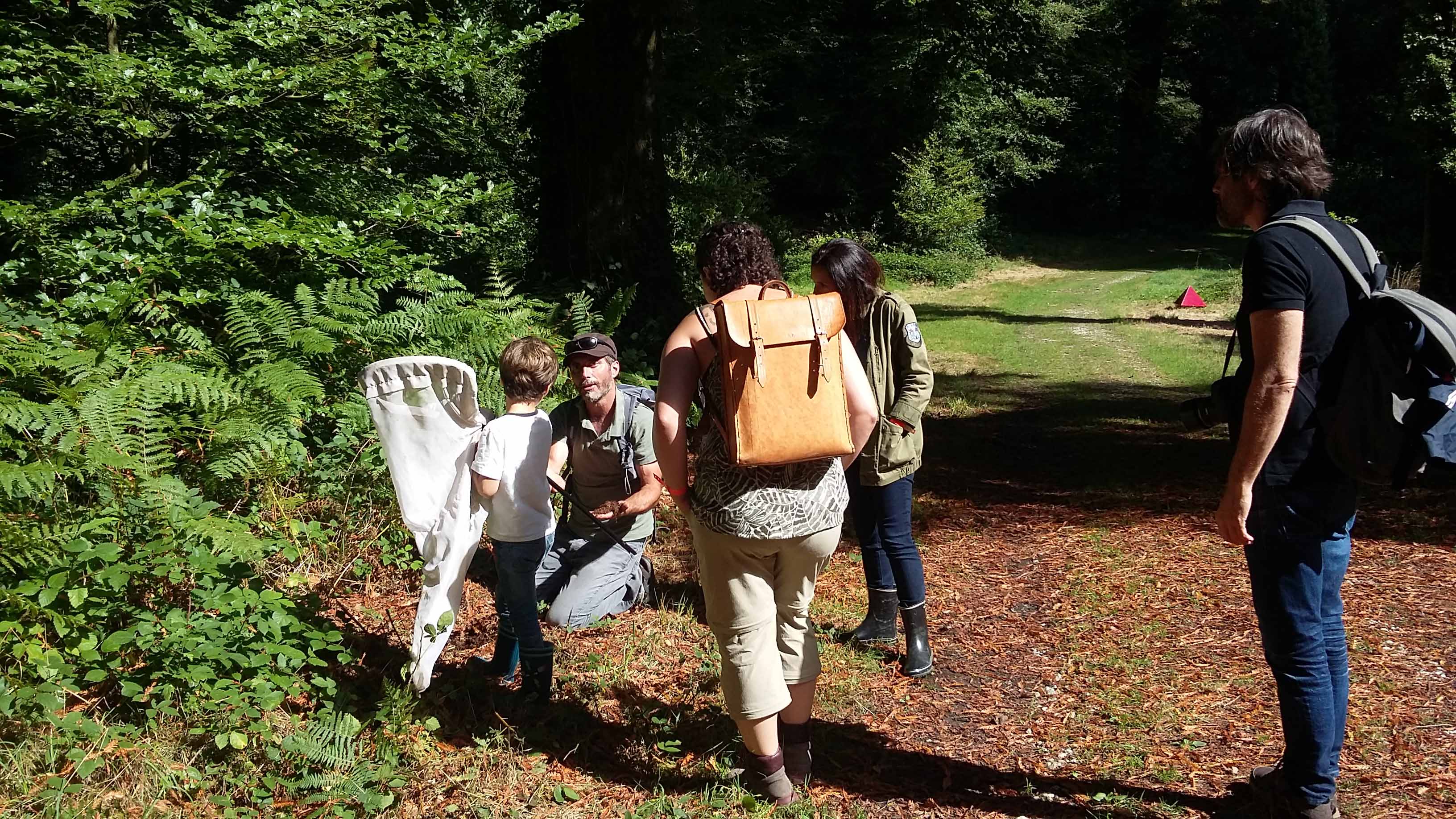 Homme parlant à un groupe dans une forêt.