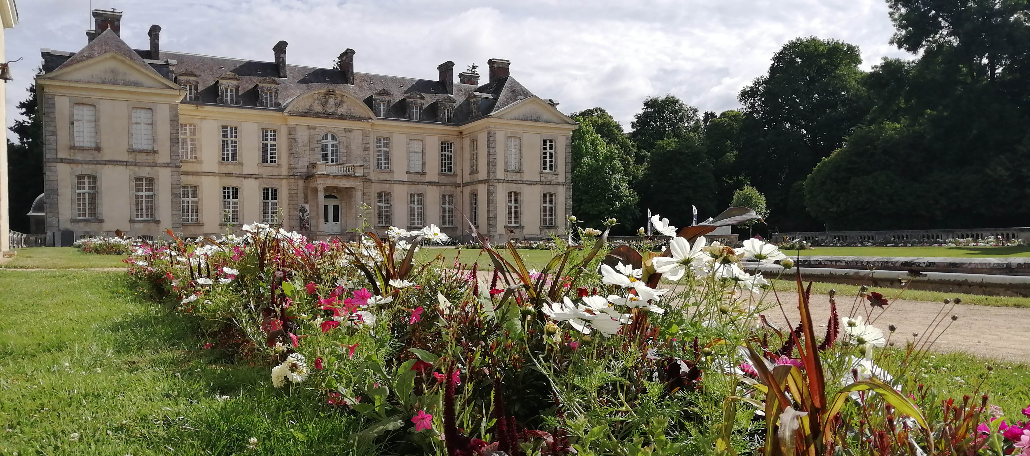 Visuel de fleurs au premier plan et du château à l'arrière plan.