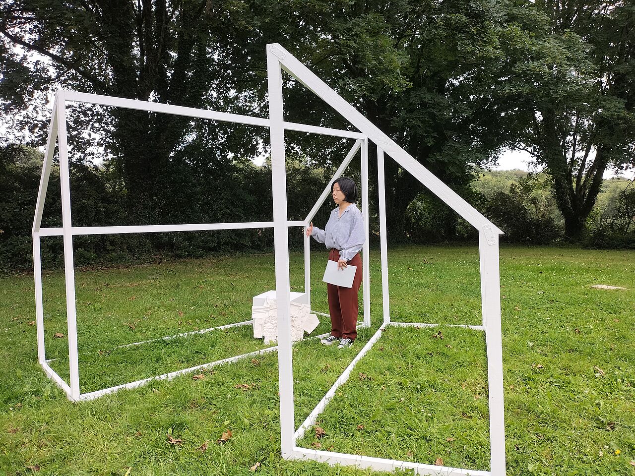 photo de l'artiste dans sa construction, une maison blanche en relief