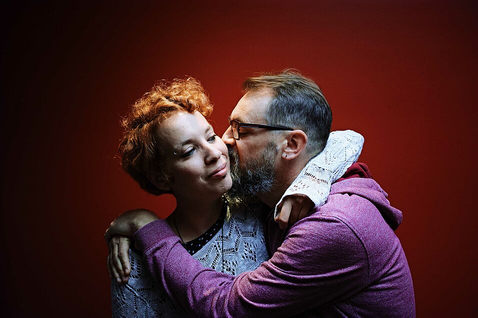 Photo d'un homme embrassant sur la joue une femme.