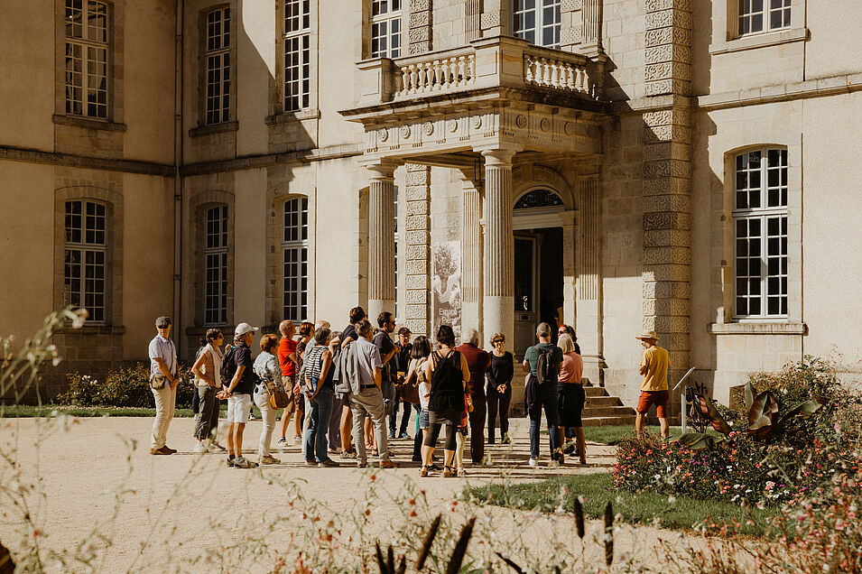 photo de public devant le chateau en train d'assister à une visite guidée