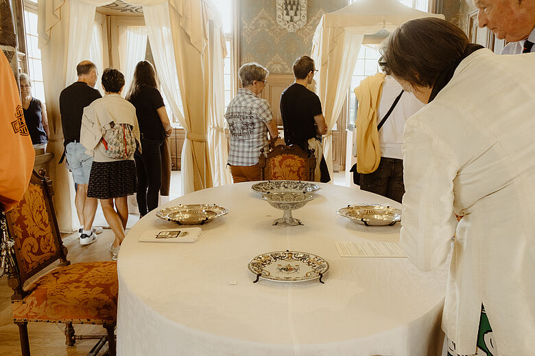 photo d'une salle d'exposition où l'on voit le public autour d'une table dressée