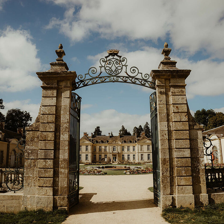 photo prise devant la grille d'entrée de la cour d'honneur avec le château en fond